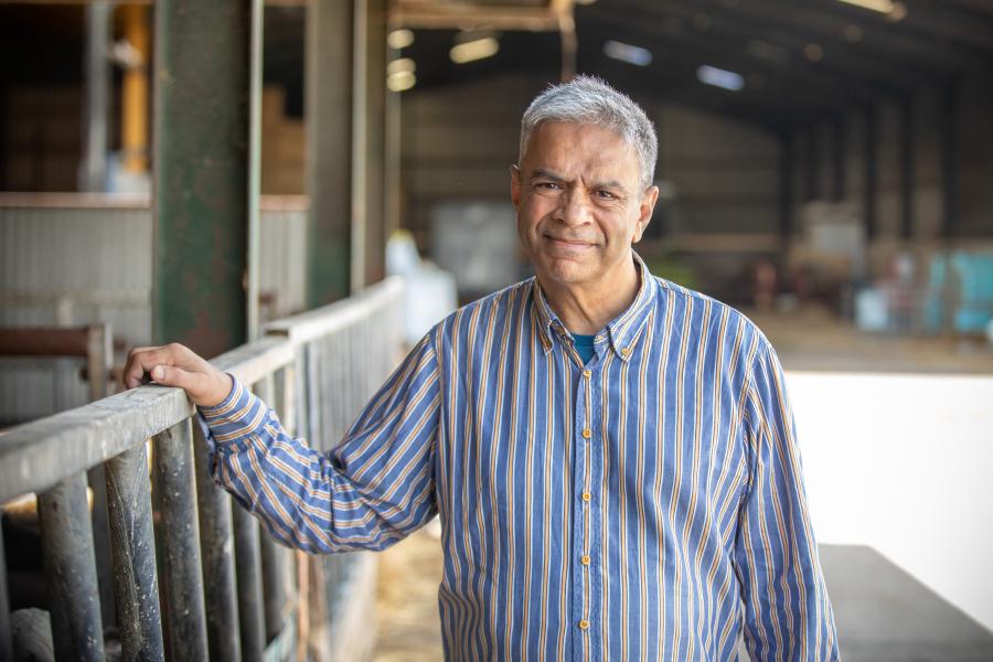 Person standing with agricultural buildings in the background