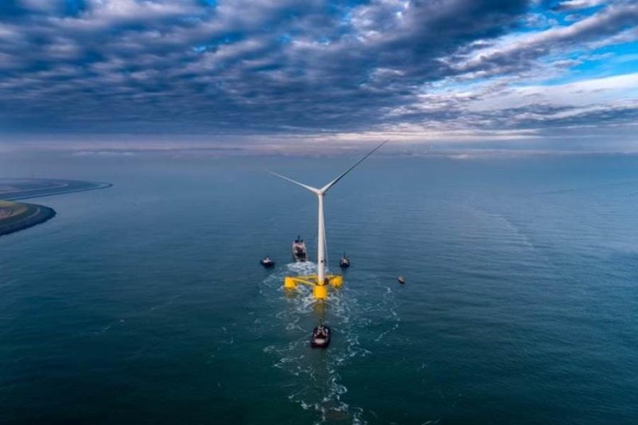 Looking down at a single floating wind turbine sitting on three yellow 'feet'