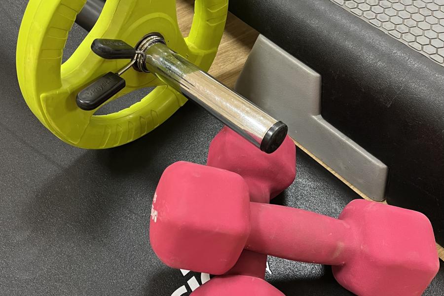 A selection of weights with a mat and a step used in Body Blast.