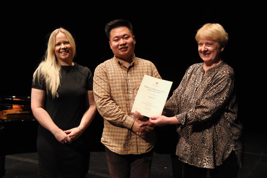 Three people standing holding a certificate