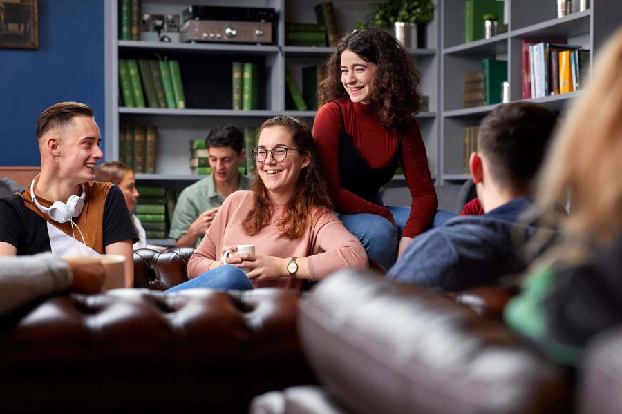 A group of students socialising and relaxing in Barlows at St Mary's Student Village