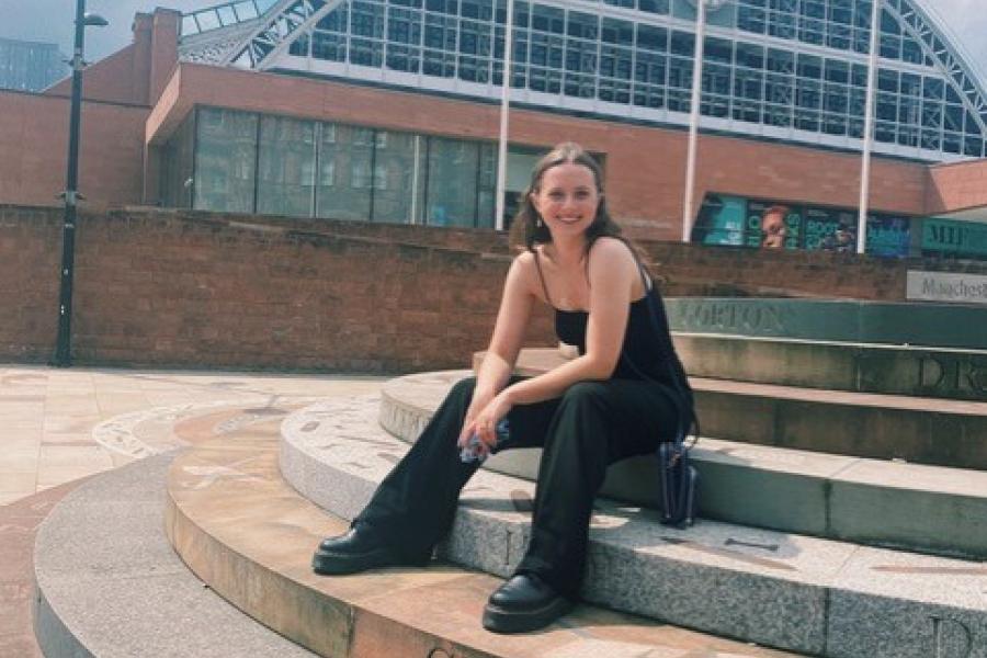 Hannah Sitting on steps smiling at the camera 