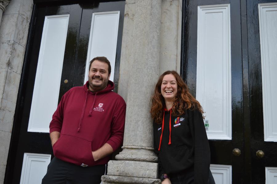  two people stand outside Penrhyn Hall, Bangor