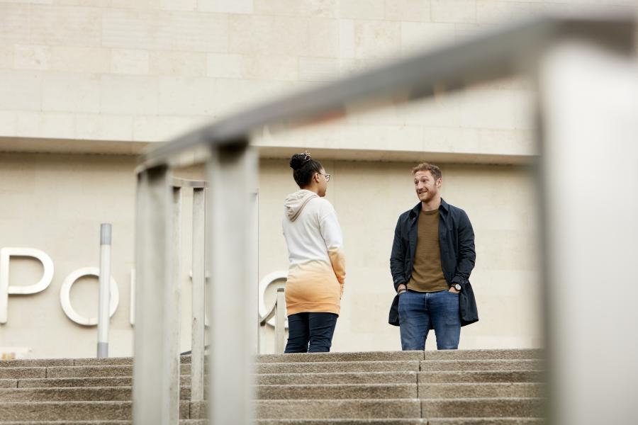 Two students chatting outside Pontio 