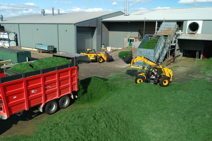 Harvesting grass in a field with farming machinery