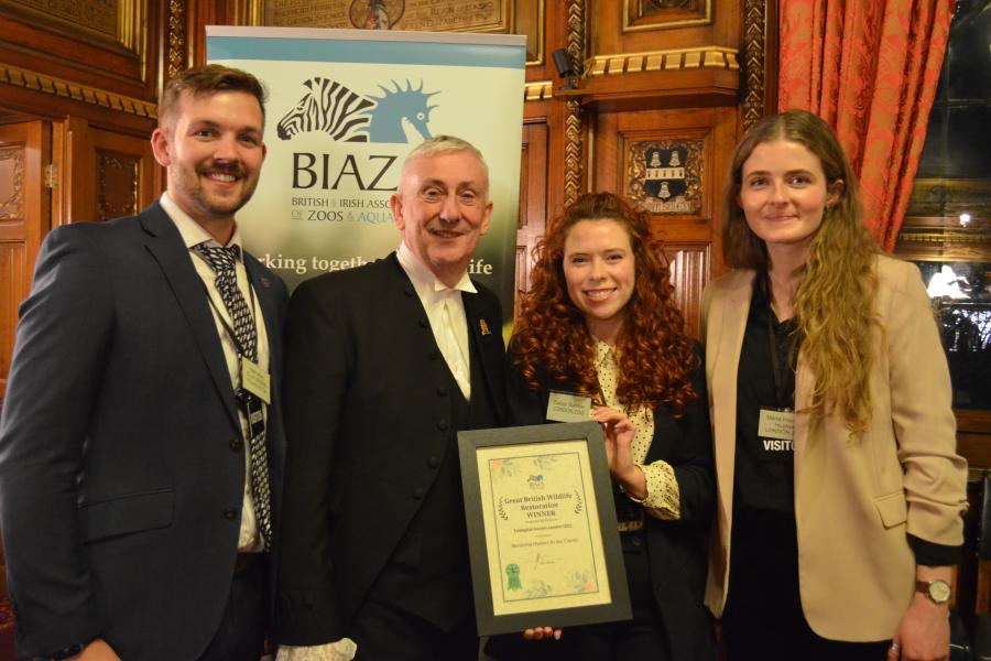 Two men and two women hold a certificate