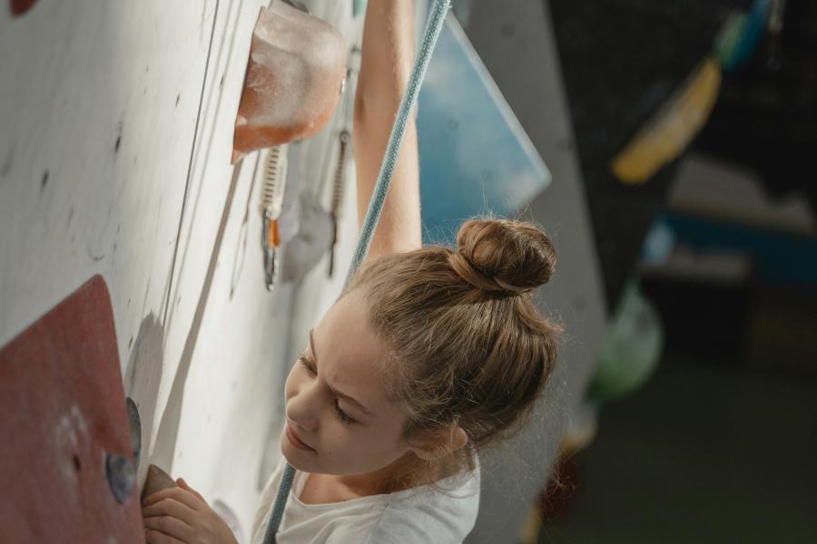 Young girl climbing on an indoor wall