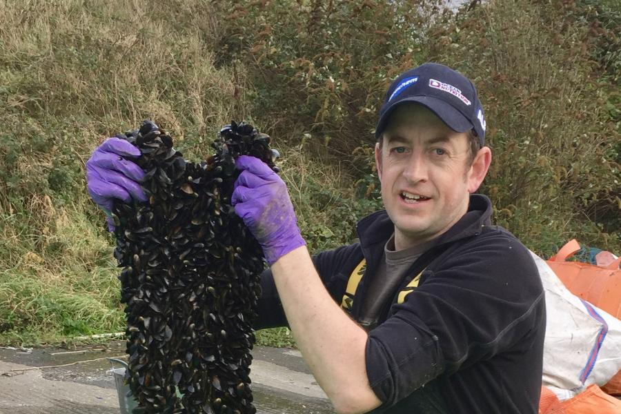 Image of Dr Nick Jones holding up mussels