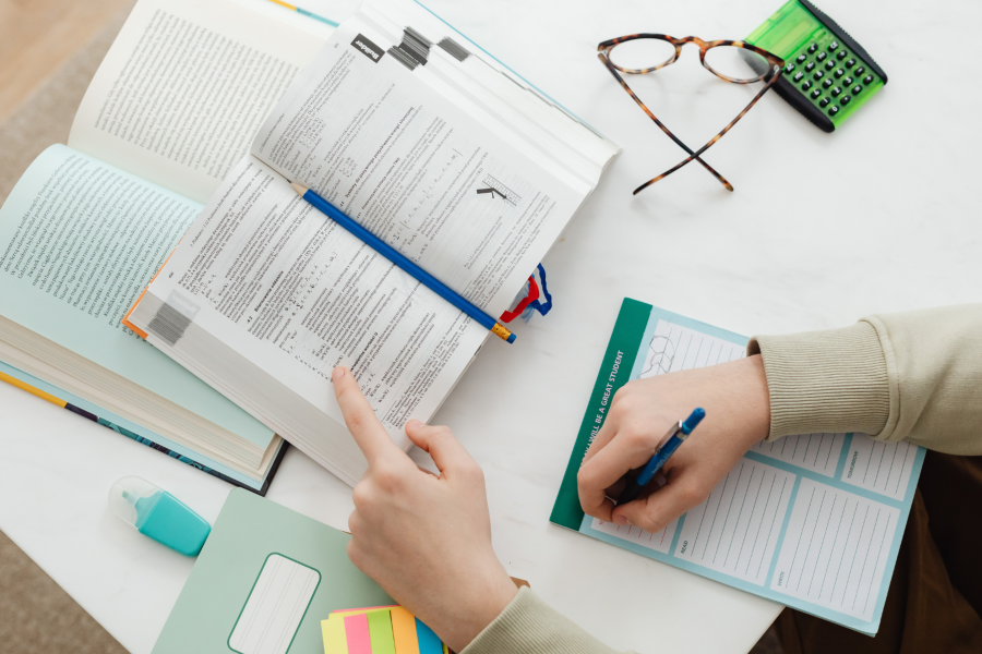 Person with books, glasses and calculator