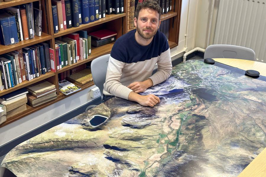 Person sitting at a desk with a map