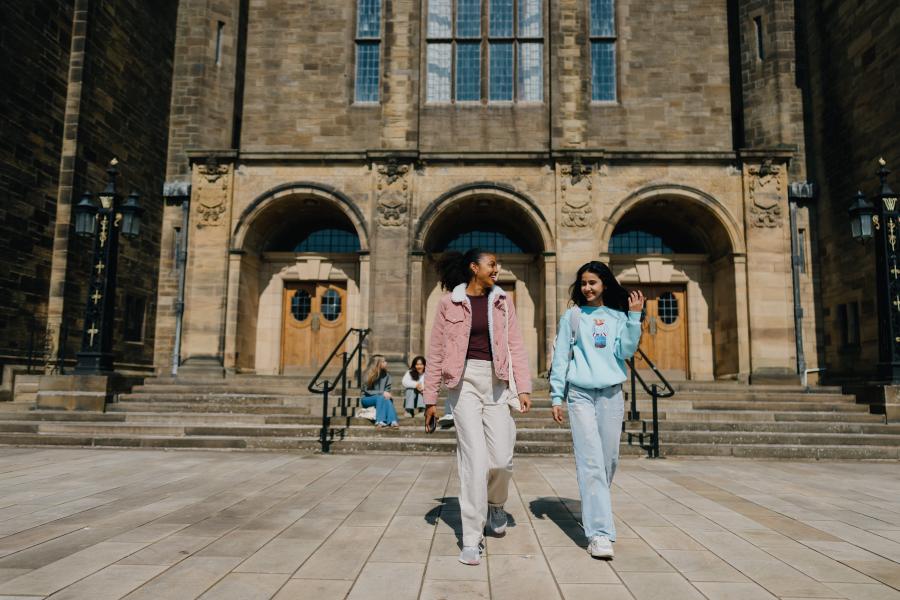 Two students walking in the quad 