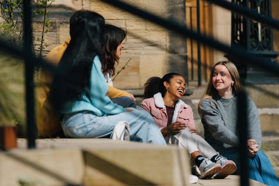 Group of students sitting on some steps talking