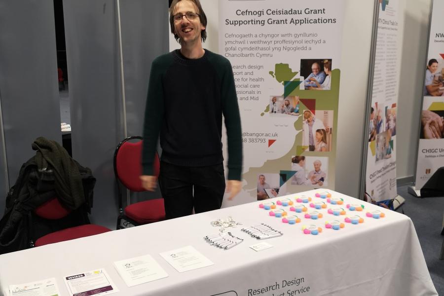Man stood behind stall at research conference