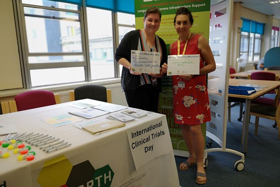 two women standing holding certificates