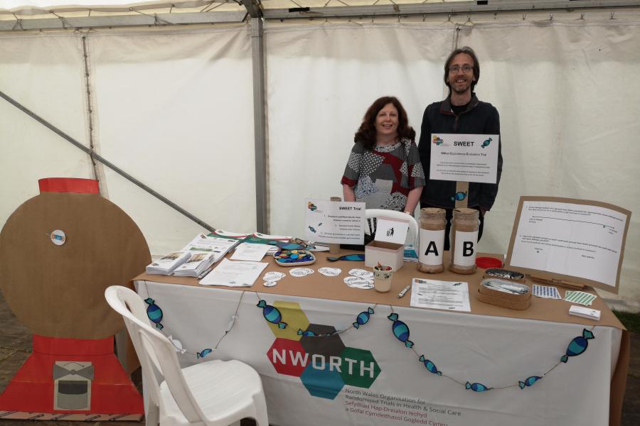 man and woman standing behind stall at research event
