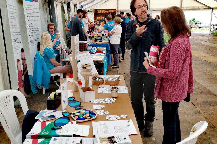 Man talking to woman in front of stall at research event