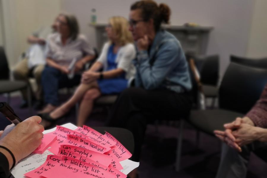 Close-up of pink post-it notes with writing on
