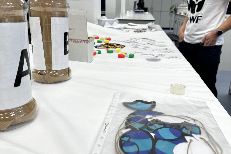 Man smiling talking to woman behind a stall at a research event