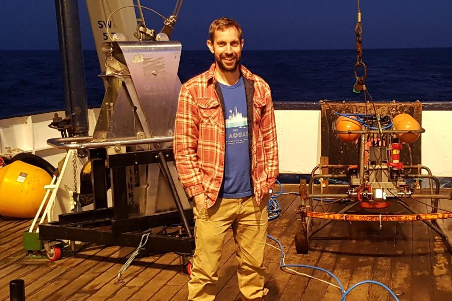 Dr Tim Whitton on a research vessel at night on the sea