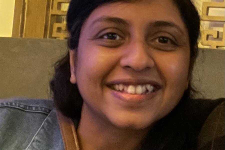 Dr Azlina smiling to the camera, wearing blue denim jacket