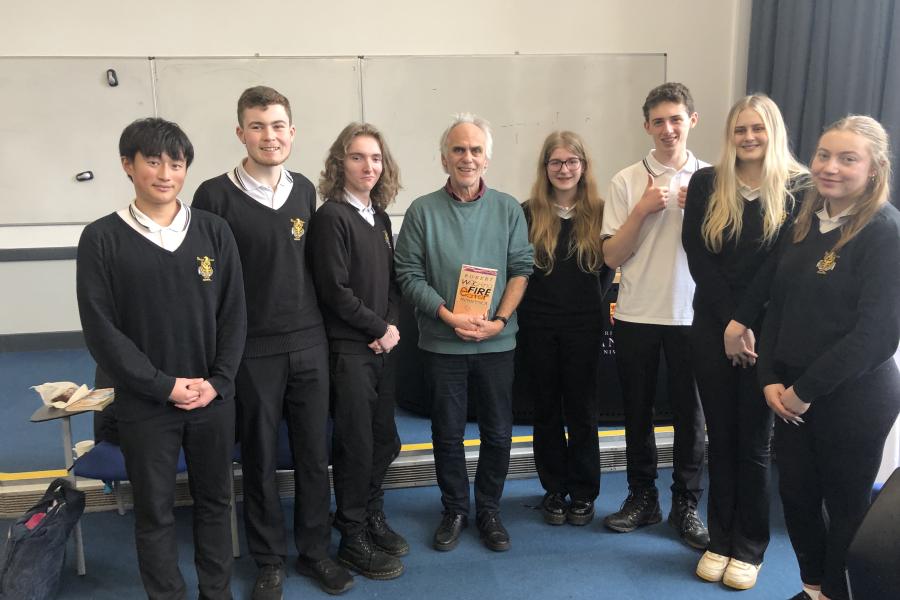A group of 7 sixth form students surrounding a local author who visited the school to run a workshop