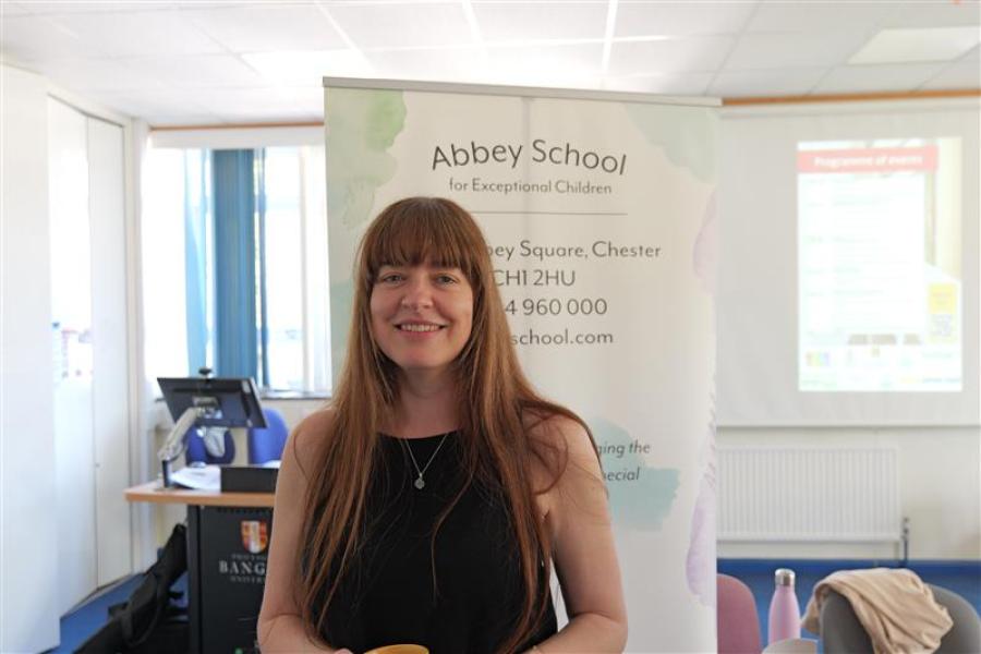 Employer smiling to camera in front of banner stand
