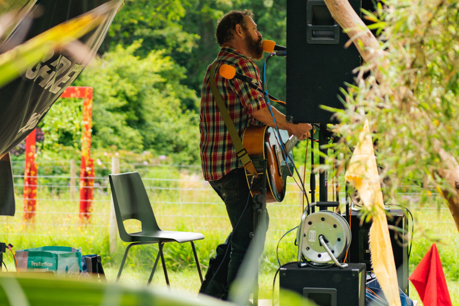 Man on stage with guitar in a festival