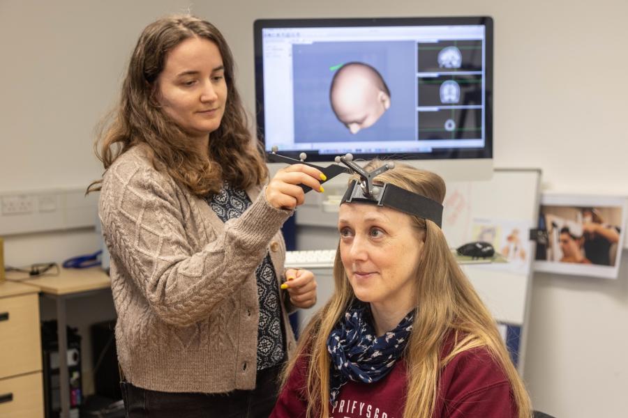 A researcher doing an experiment on a participant who is smiling