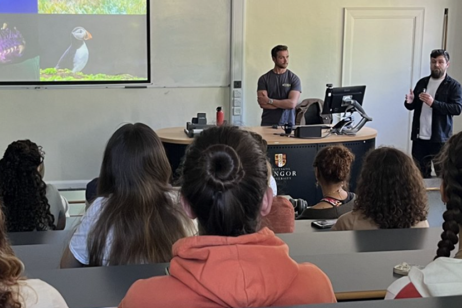 Two alumni presenting to students in lecture theatre