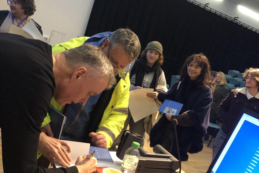 Poet Tom Jenks signing books for students