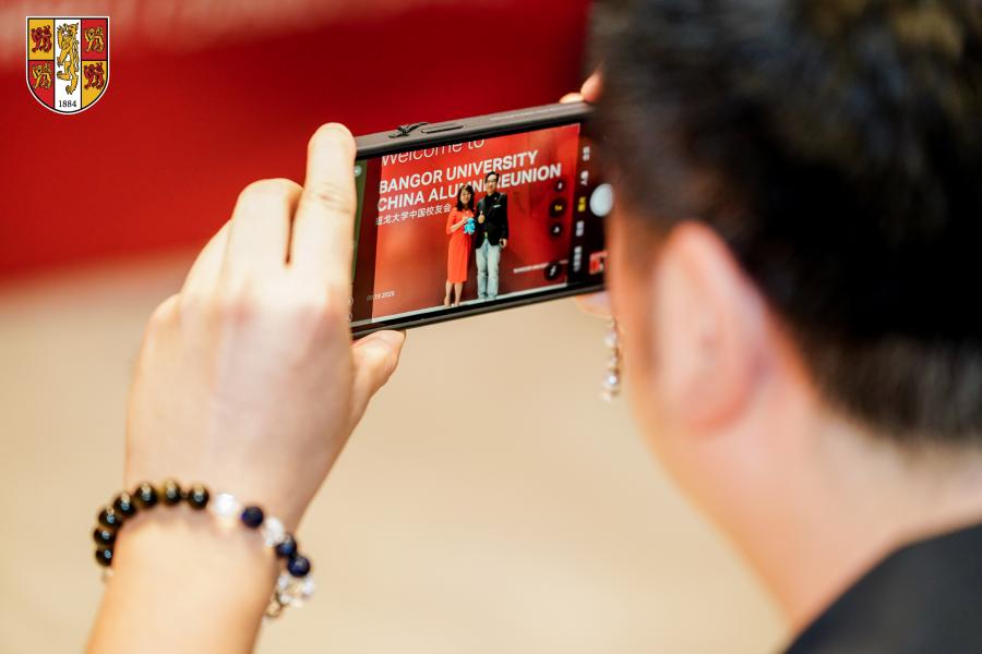 Alumni having their photo taken against reunion banner