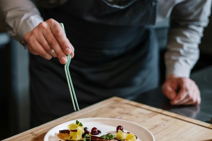 Person Holding Fork and Knife Slicing Vegetable on White Ceramic Plate  More info  Share