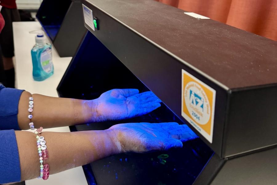 Young persons hands being analysed and screened for germs 