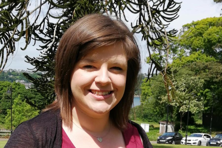 Image of Dr Sarah Cooper outside with a large monkey tree behind her