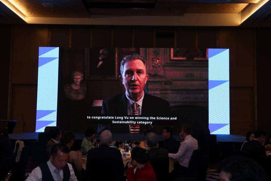 Prof. Oliver Turnbull on screen congratulating Long Vu