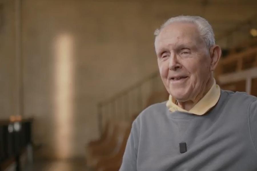 An image of Bernard smiling to someone off camera in a large lecture theatre