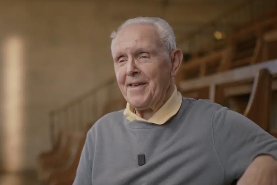 An image of Bernard smiling to someone off camera in a large lecture theatre