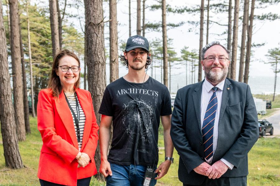 Film and Media graduate Kieran Samuel smiling on the set of House of the Dragon with Professor Ruth McElroy and Bangor University Vice-Chancellor Professor Edmund Burke.