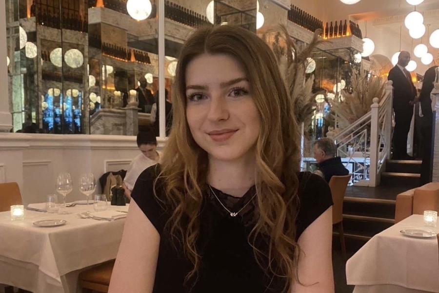 Head and shoulder shot of Cassie in a restaurant smiling to the camera