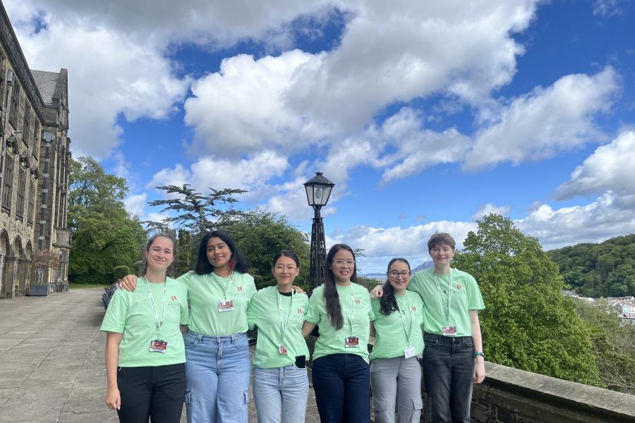 Wide shot of the Student Wellbeing Ambassadors standing outside Main University Building at Bangor University