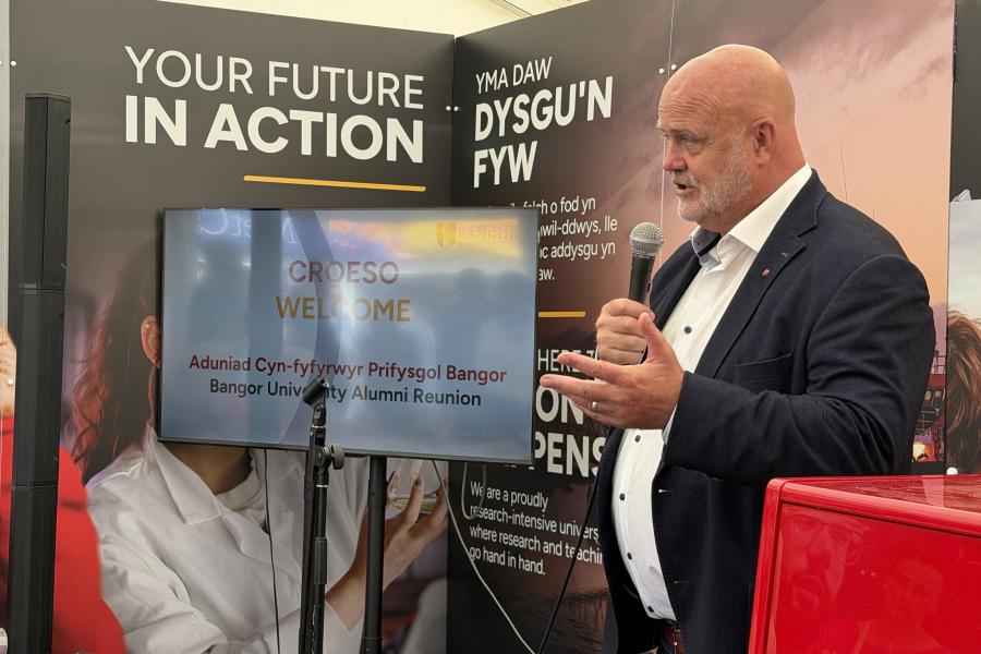 Emyr Afan yn siarad i fewn i'r meicroffon
