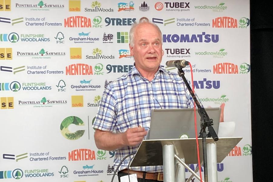Trefor Owen yn siarad o flaen podiwm