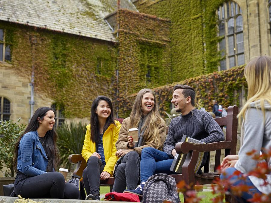 Students socialising on a bench in the inner quad of the University's Main Arts building