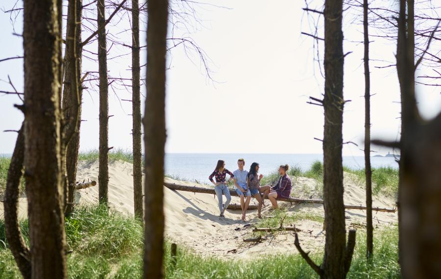 Students sitting on the beach in nearby Llanddwyn