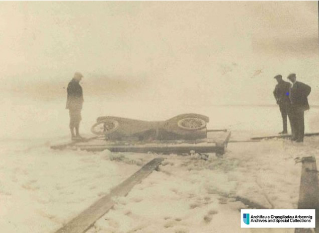 Photo of a partially submerged car broken through the ice on a frozen Llyn Tegid