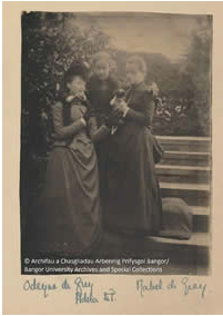 Photo of Adela Douglas Pennant (1858-1955), who is standing in the middle of the picture with her arms around the shoulders of her companions