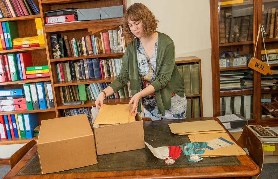 A Volunteer in the archives looking at uncatalogued documents in boxes