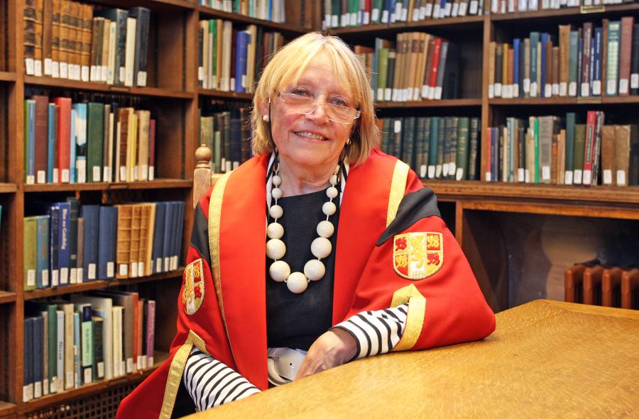 Photo of Dr Pauline Cutting in Bangor University library wearing graduation gown