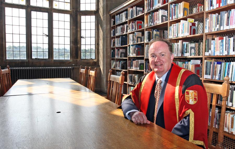 Photo of Dr Dafydd R Owen in Bangor University library in graduation gown