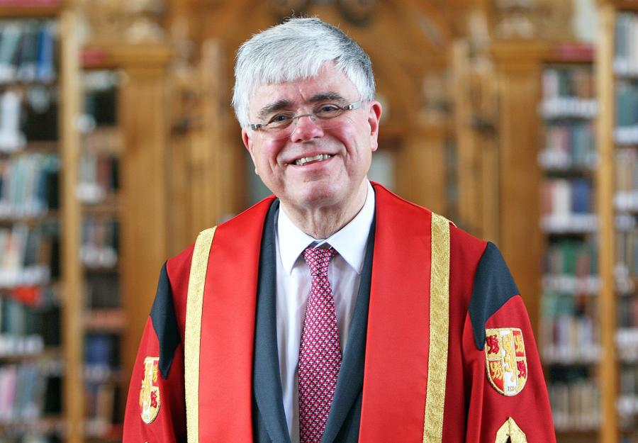 Photo of Professor Iwan Davies in Bangor University library in graduation gown